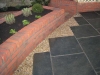 Paving surrounded by raised flower beds